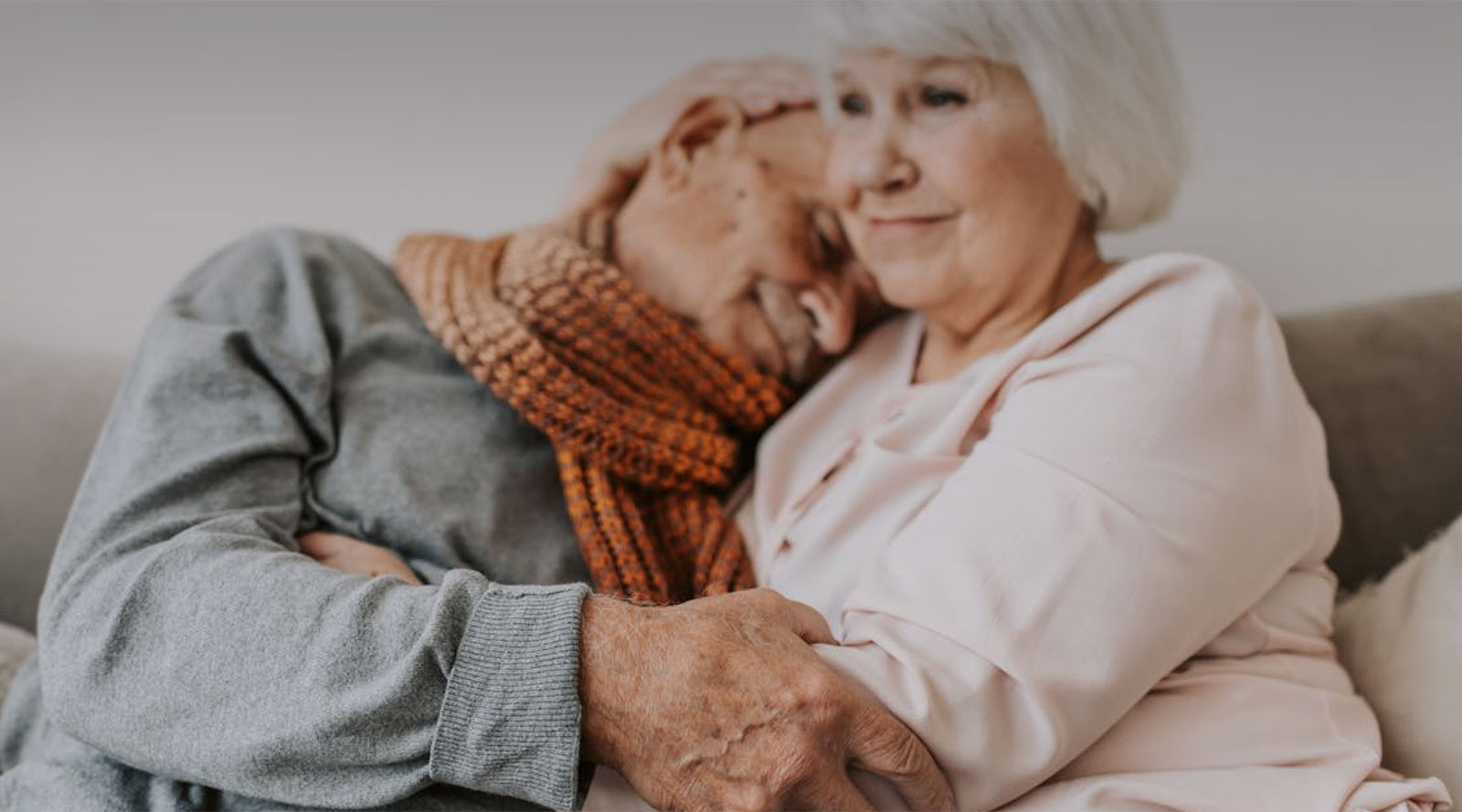 Older couple snuggling on the couch